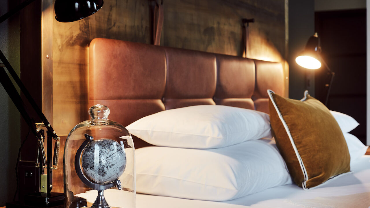 Gastwerk Hotel Hamburg L Loft Zimmer 23 Gemütliches Bett im L-Loft von der Seite mit Nachttischlampe