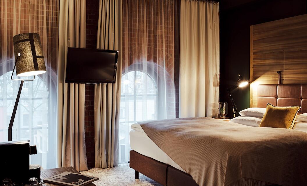 Gastwerk Hotel Hamburg S Loft Zimmer 3 Bett, große Fensterfront mit Backsteinwand, Fernseher und Stehlampe