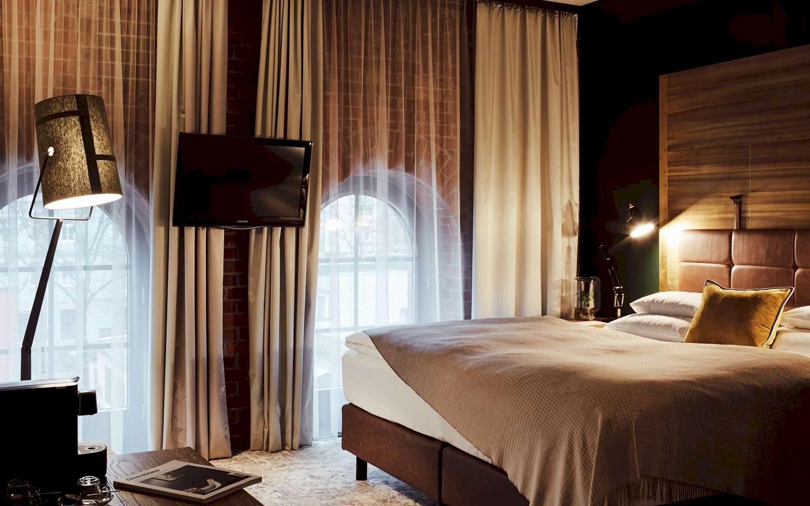 Gastwerk Hotel Hamburg S Loft Zimmer 3 Bett, große Fensterfront mit Backsteinwand, Fernseher und Stehlampe