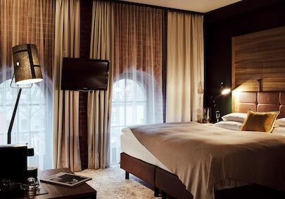 Gastwerk Hotel Hamburg S Loft Zimmer 3 Bett, große Fensterfront mit Backsteinwand, Fernseher und Stehlampe