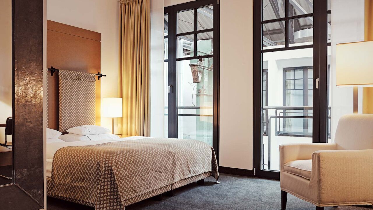 Gastwerk Hotel Hamburg S Loft Atrium Zimmer 8 Bett und Sessel im S-Loft mit Blick in die Hotellobby