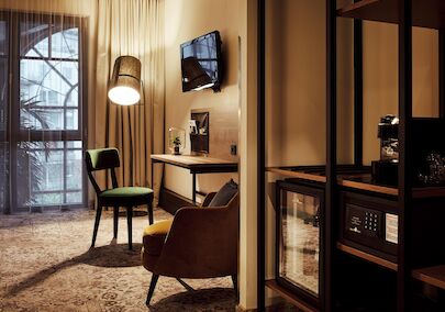 Gastwerk Hotel Hamburg S Loft Atrium Zimmer 4 Zimmer mit Schreibtisch, TV, Sessel, Wandregal, Minibar und Safe