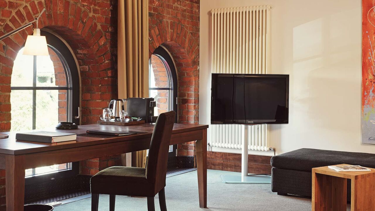 Gastwerk Hotel Hamburg Xl Loft Zimmer 15 Ein Schreibtisch und TV im XL-Loft mit Backsteinwand
