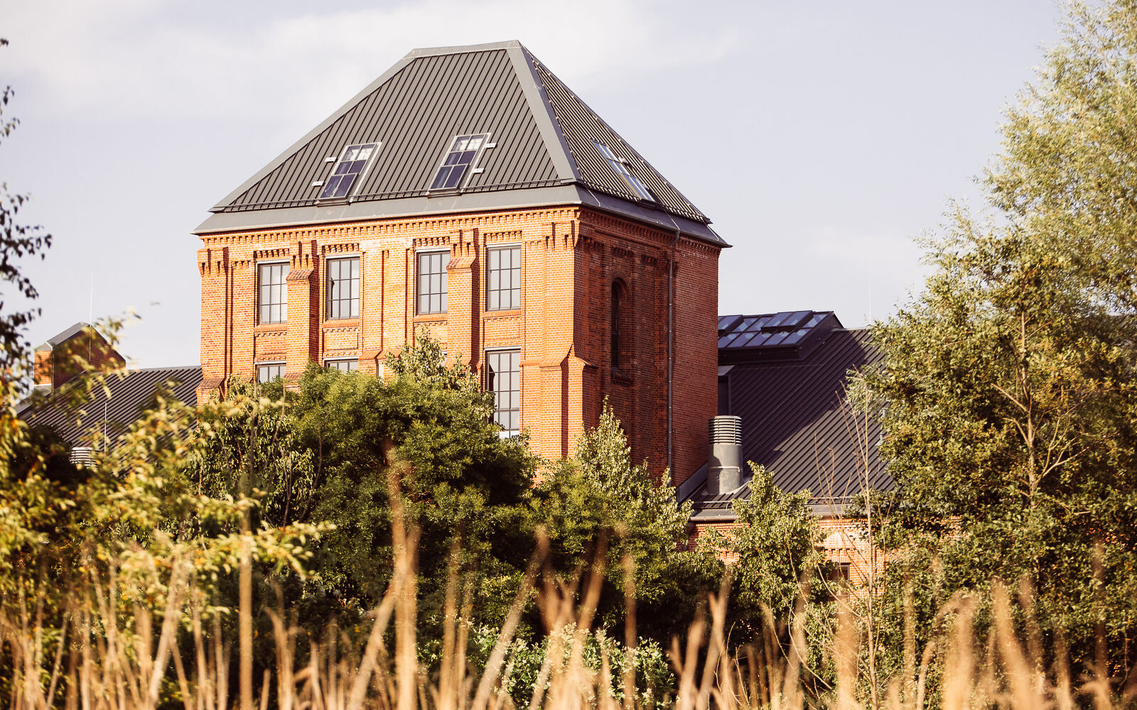 Gastwerk Umgebung 5 No Exi Gastwerk Hotel Gebäudeansicht hinter grünen Baumkronen