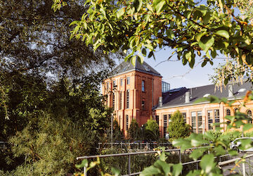 Gastwerk Hotel von Bäumen und Pflanzen eingerahmt, Außenansicht