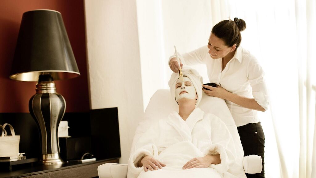 Gastwerk Hotel Hamburg Day Spa 08 Behandlung Gesicht Professionelle Kosmetikerin trägt einer Frau im Spa eine Maske auf