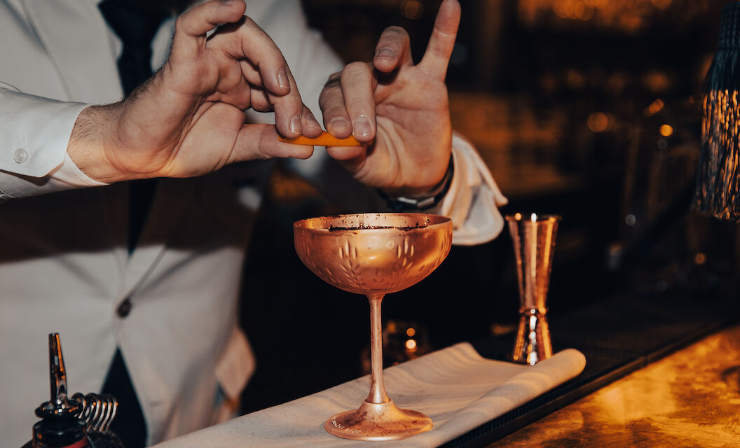 Gastwerk Hotel Hamburg Bar Mangold 11 Messing Martiniglas über dem eine Zitronenzeste ausgedrückt wird