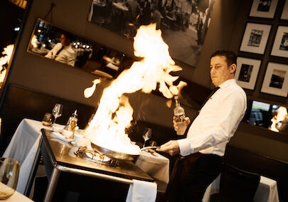 Scampi being flambéed by waiter at DaCaio restaurant