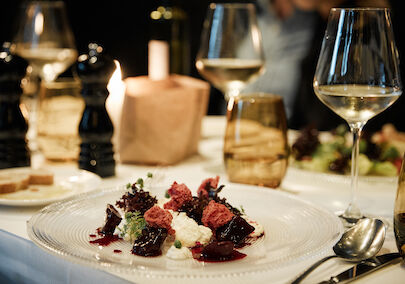 Close up of burrata in the background a wine glass