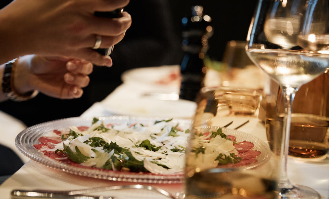 Tartare in focus with person grinding pepper