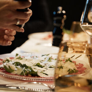 Tartare in focus with person grinding pepper
