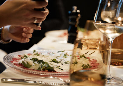 Tartare in focus with person grinding pepper