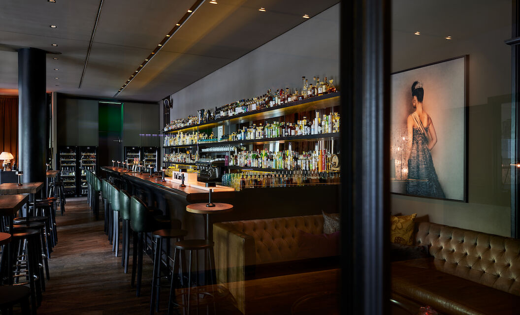 Long bar with fully stocked shelf of various spirits in view