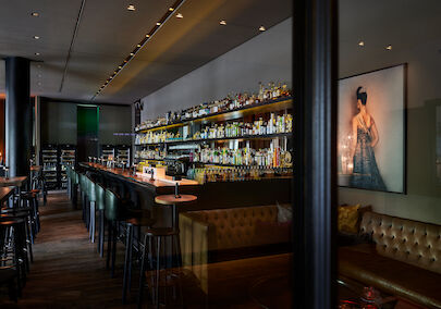 Long bar with fully stocked shelf of various spirits in view
