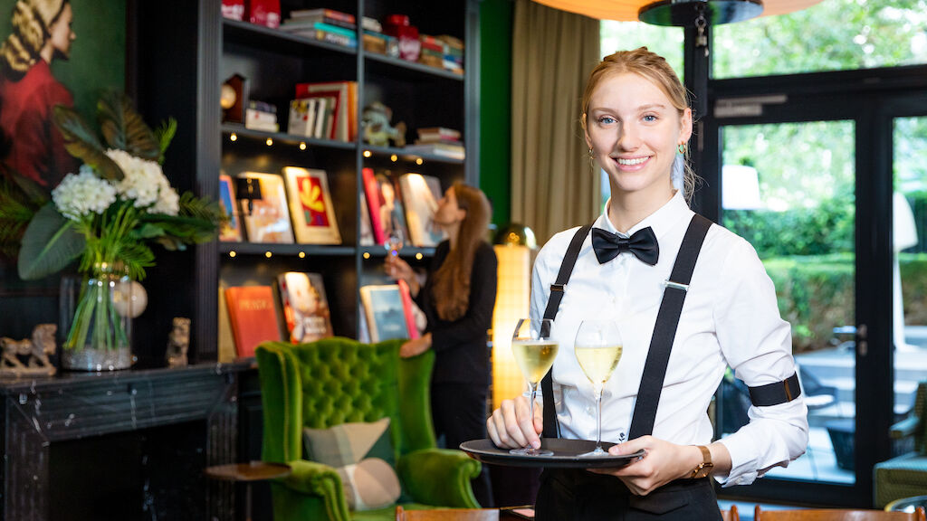 Servicemitarbeiterin serviert serviert Champagner in der Private Library
