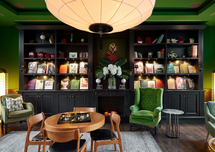 Tagungsraum Private Library mit Sessel, Holztisch und Bücherwand im Hintergrund