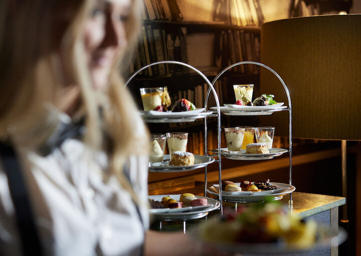 Two stands of finger food in Clubroom, waitress blurred in foreground