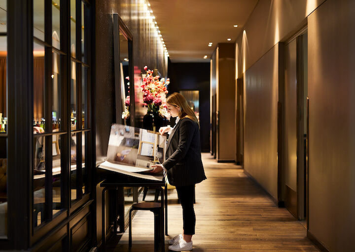 Buchwerk Hamburg Lobby 08 Frau blättert im Design Hotels Buch im Flur des Buchwerk