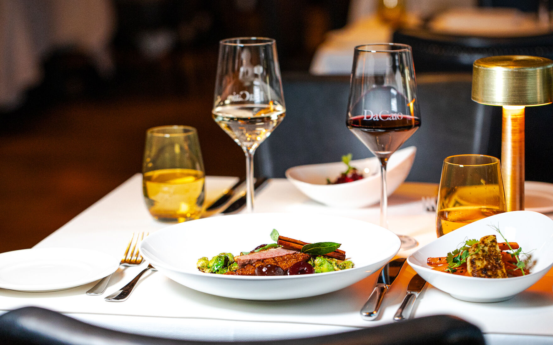 Gedeckter Tisch mit Speisen, Wein und Wasser im DaCaio Restaurant