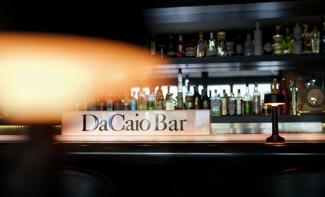 Lamp foreground with spirits rack and DaCaio Bar logo behind