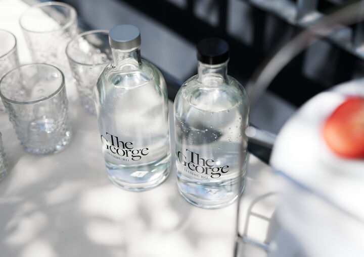 Water bottles branded with The George placed on table outdoors