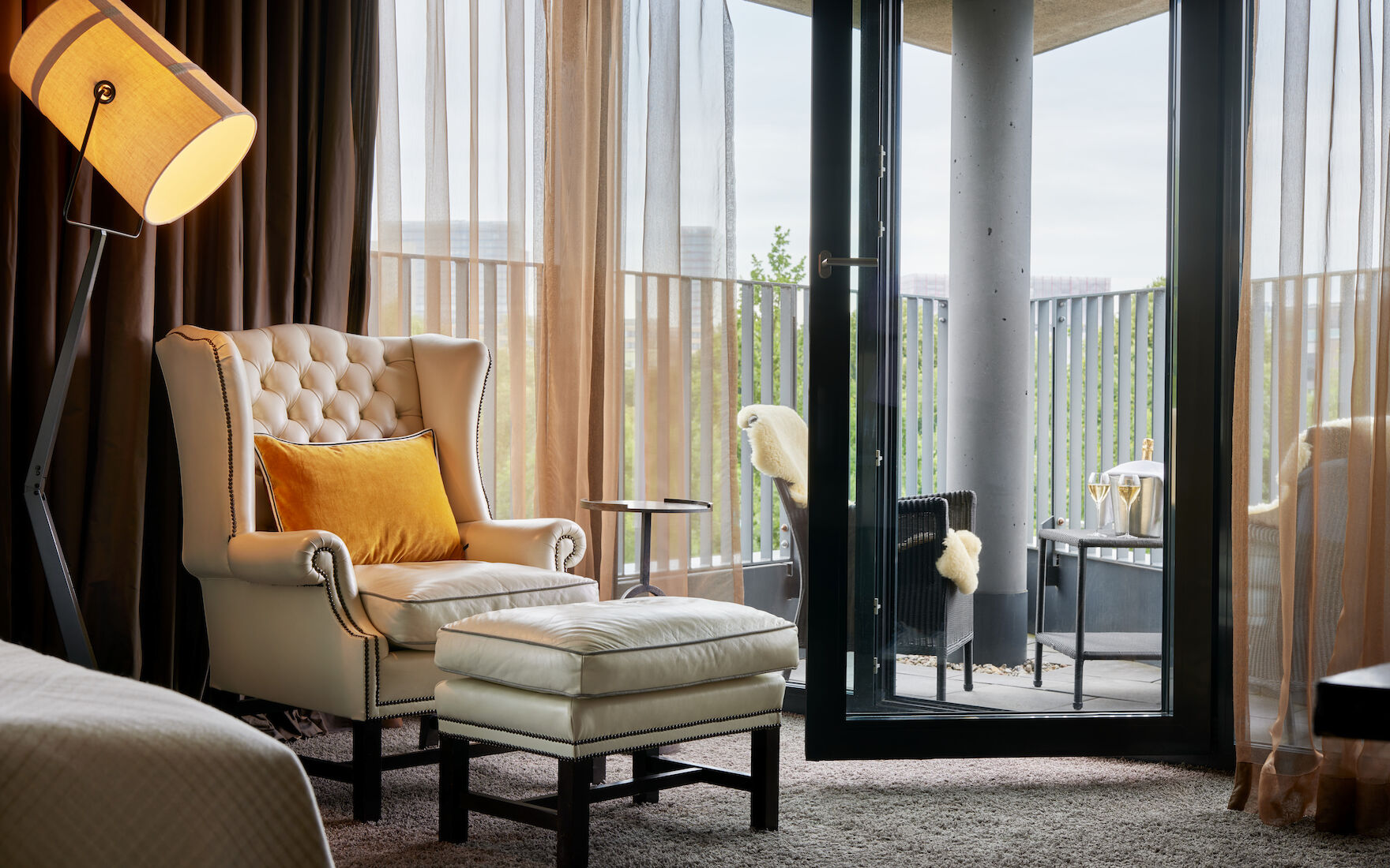 The George Hotel Hamburg Zimmer Juniorsuite 04 Chesterfield armchair with footstool, pointed balcony with seating behind