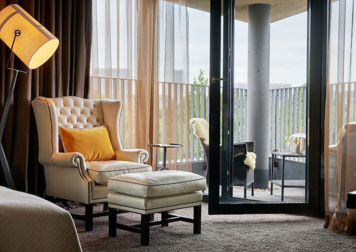 The George Hotel Hamburg Zimmer Juniorsuite 04 Chesterfield armchair with footstool, pointed balcony with seating behind