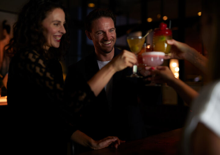 People toast with cocktails in a friendly gathering