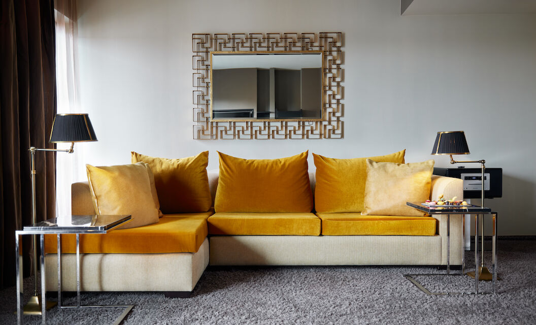 The George Hotel Hamburg Zimmer The George Suite 03 Large mustard sofa in front of mirror in hotel suite