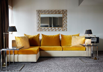 The George Hotel Hamburg Zimmer The George Suite 03 Large mustard sofa in front of mirror in hotel suite