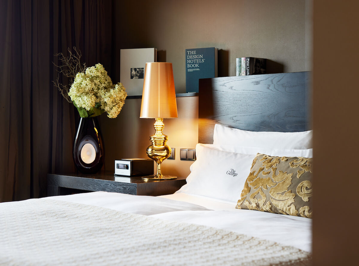 Side view of headboard with golden lamp and books in the background