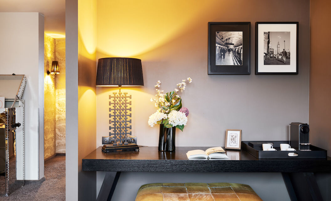 The George Hotel Hamburg Zimmer The George Suite 04 Desk with floor lamp, book, decor and two framed pictures on wall