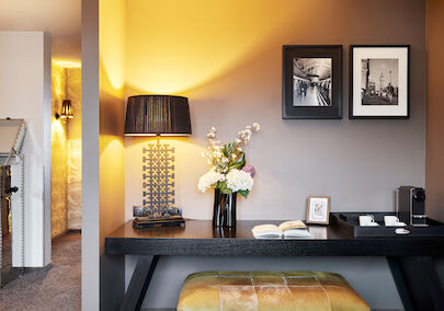 The George Hotel Hamburg Zimmer The George Suite 04 Desk with floor lamp, book, decor and two framed pictures on wall