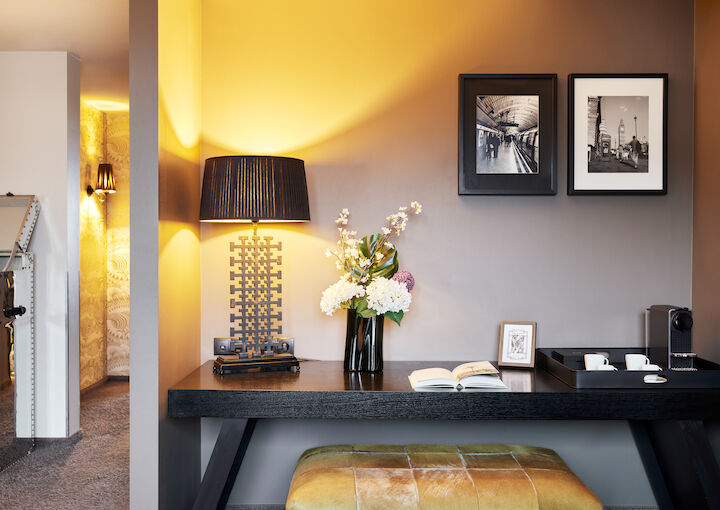 Desk with floor lamp, book, decor and two framed pictures on wall