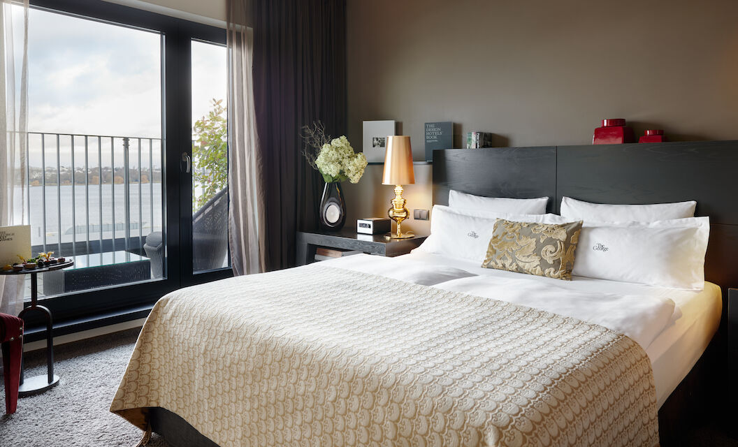 The George Hotel Hamburg Zimmer The George Suite 015 The George Suite with bed and large glass door to Alster view