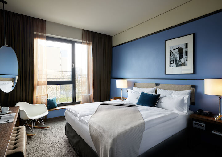 Kingsize bed in front of blue wall with wall decor in S-Room.