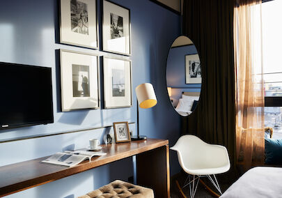 The George Hotel Hamburg Zimmer S Room 02 Room corner with wall art, narrow table, and Eames armchair