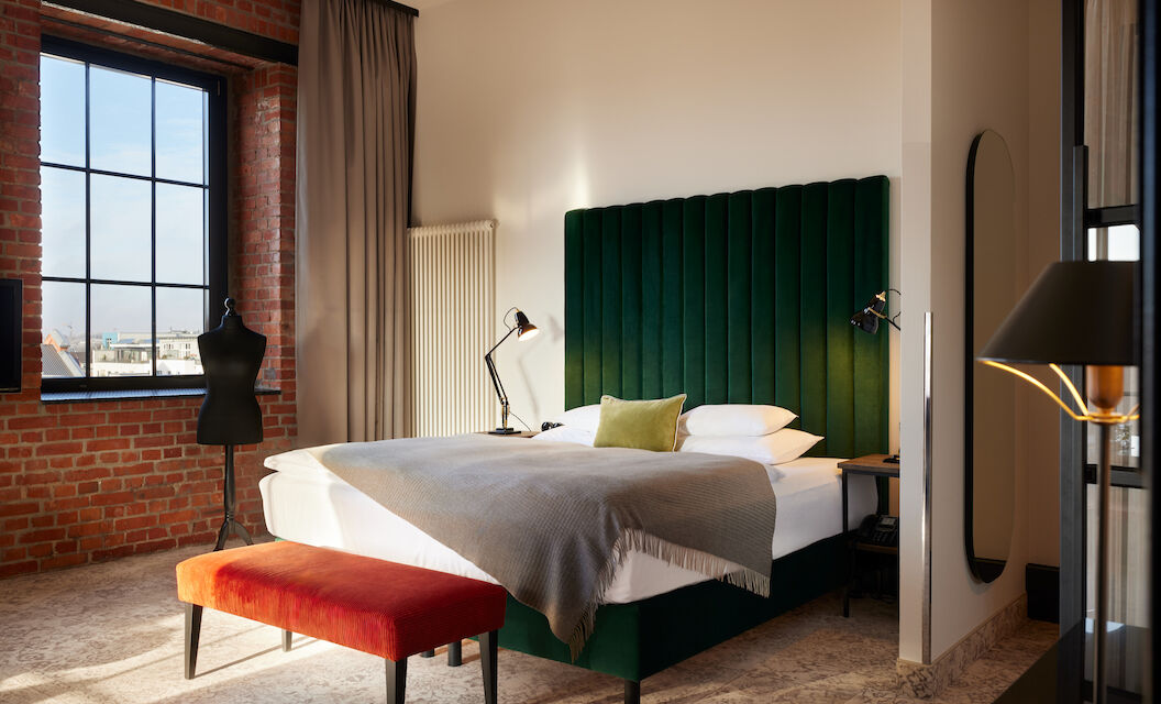 Gastwerk Hotel Hamburg Zimmer Xl Loft 554 01 Kingsizebett mit grünem Samtkopfteil und Schneidepuppe vor Backsteinwand