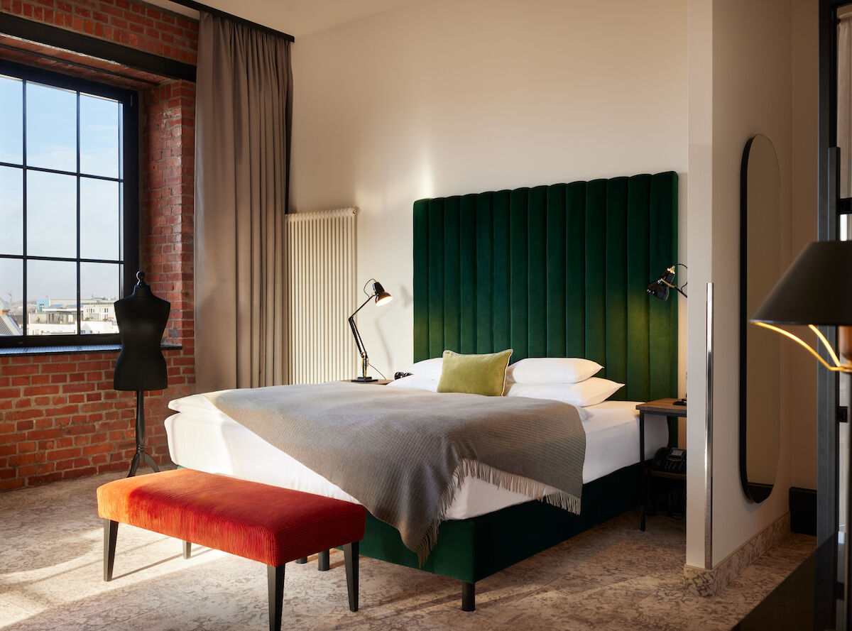 Gastwerk Hotel Hamburg Zimmer Xl Loft 554 01 Kingsizebett mit grünem Samtkopfteil und Schneidepuppe vor Backsteinwand