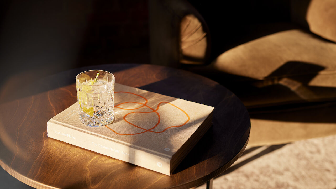 Gastwerk Hotel Hamburg Zimmer Xl Loft 554 05 Design Hotels Buch und Drink auf Beistelltisch in der Sonne.