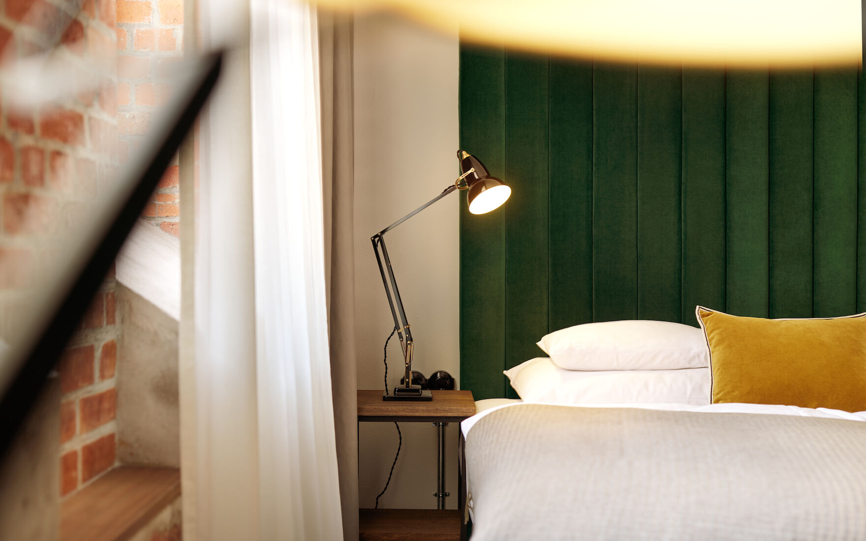 Gastwerk Hotel Hamburg Zimmer S Loft 02 Vor dem Samtkopfteil eines Doppelbetts steht eine schwarze Lampe
