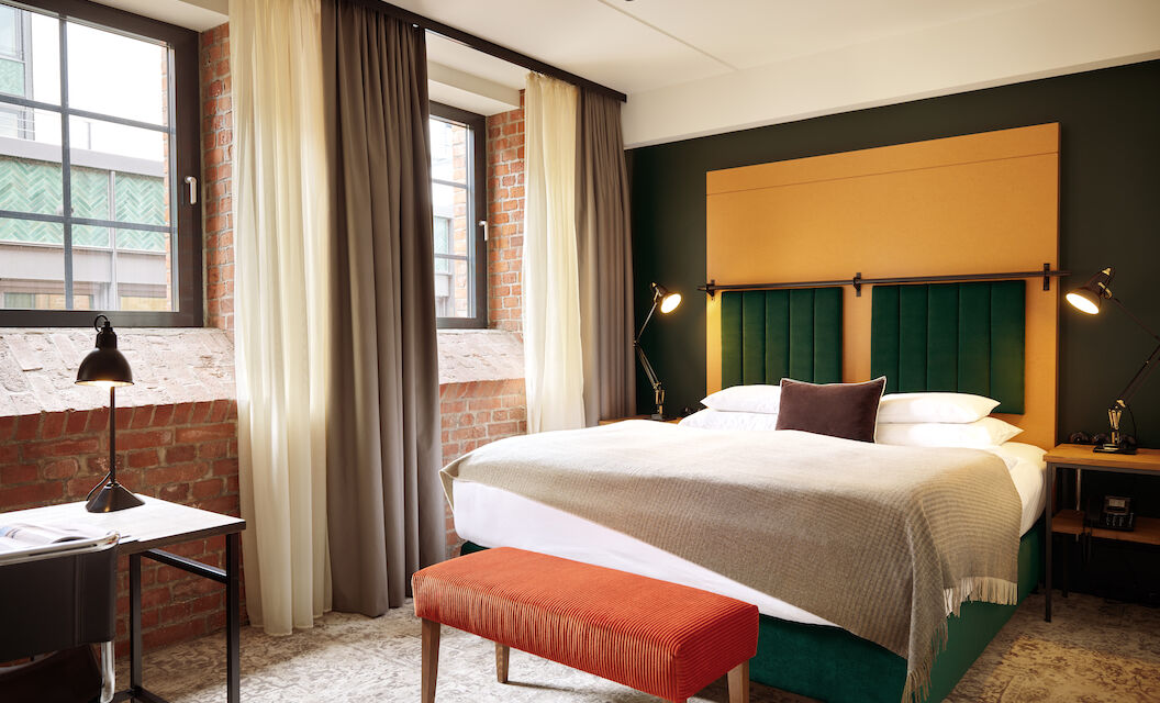 Gastwerk Hotel Hamburg Zimmer S Loft 01 Doppelbett im S-Loft mit dunkelroter Sitzbank davor.