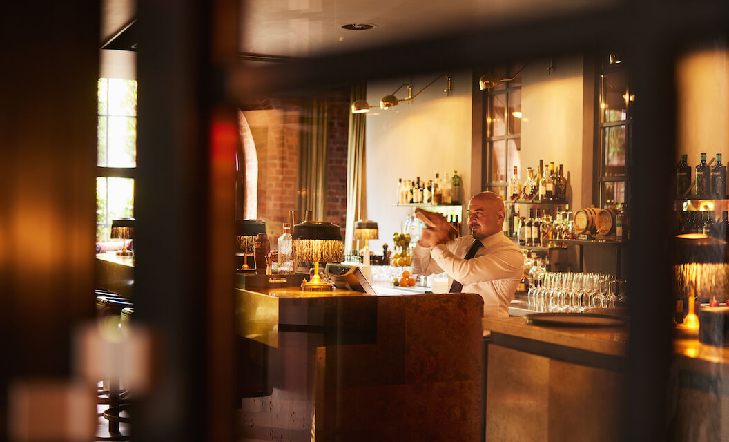 Gastwerk Hotel Hamburg Bar Mangold Atmosphaere 018 Barkeeper mixt hinter dem Tresen der Bar Mangold einen Drink.