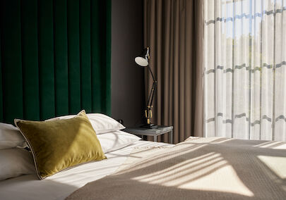 Gastwerk Hotel Hamburg M Loft Superior 03 Sonnenschein fällt durch die großen Fenster auf das Bett im Loft
