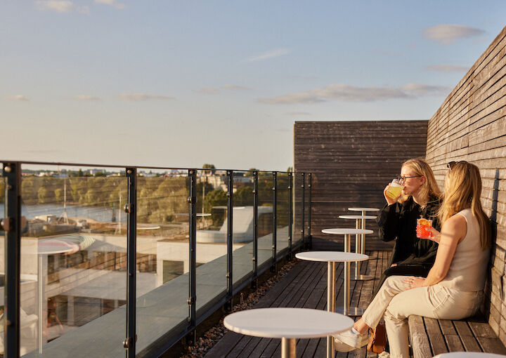 Two women enjoy their drinks on The George Rooftop.