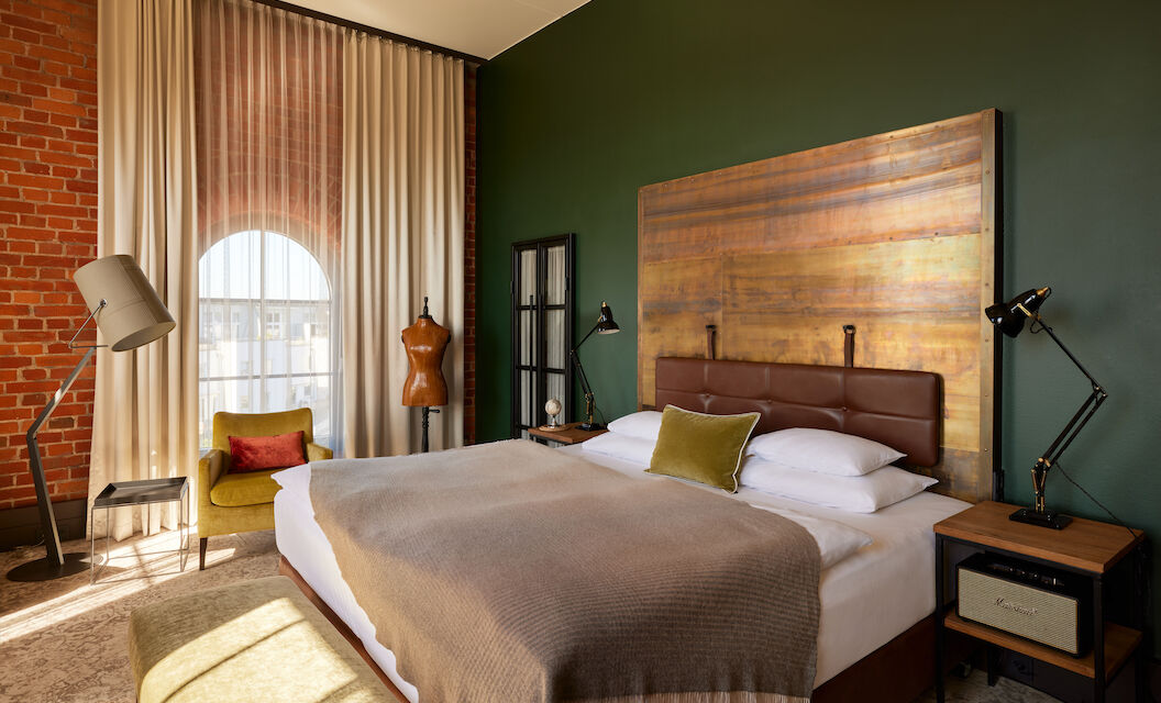 Gastwerk Hotel Hamburg Zimmer L Loft 552 01 Blick auf das Doppelbett im L Loft des Gastwerk Hotel Hamburg mit Schneiderpuppe daneben