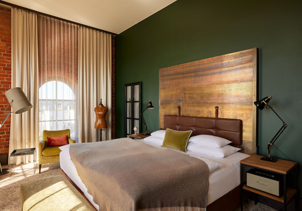 Gastwerk Hotel Hamburg Zimmer L Loft 552 01 Blick auf das Doppelbett im L Loft des Gastwerk Hotel Hamburg mit Schneiderpuppe daneben