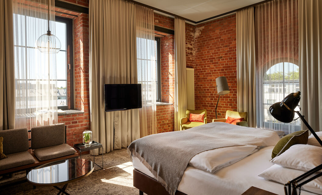 Gastwerk Hotel Hamburg Zimmer L Loft 552 02 L Loft des Gastwerk Hotel Hamburg mit Bett, Backsteinwand und gelben Sesseln
