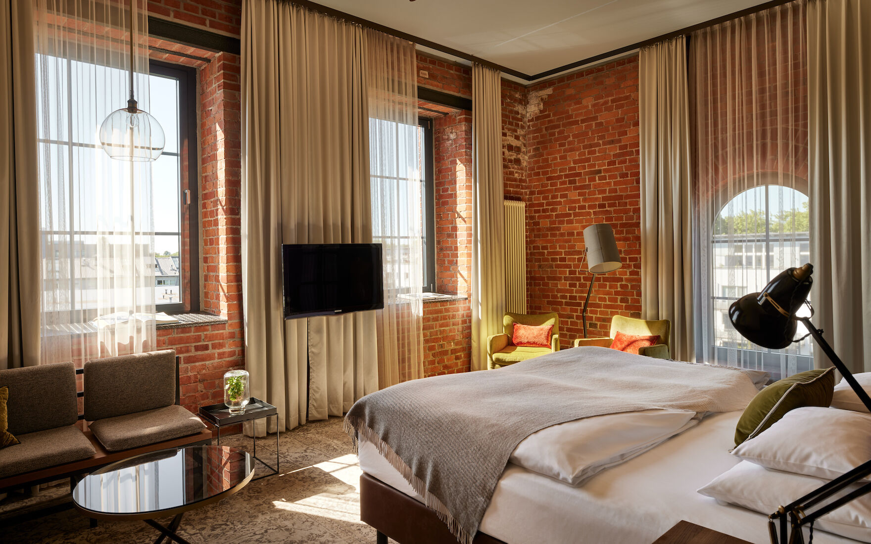 Gastwerk Hotel Hamburg Zimmer L Loft 552 02 L Loft des Gastwerk Hotel Hamburg mit Bett, Backsteinwand und gelben Sesseln